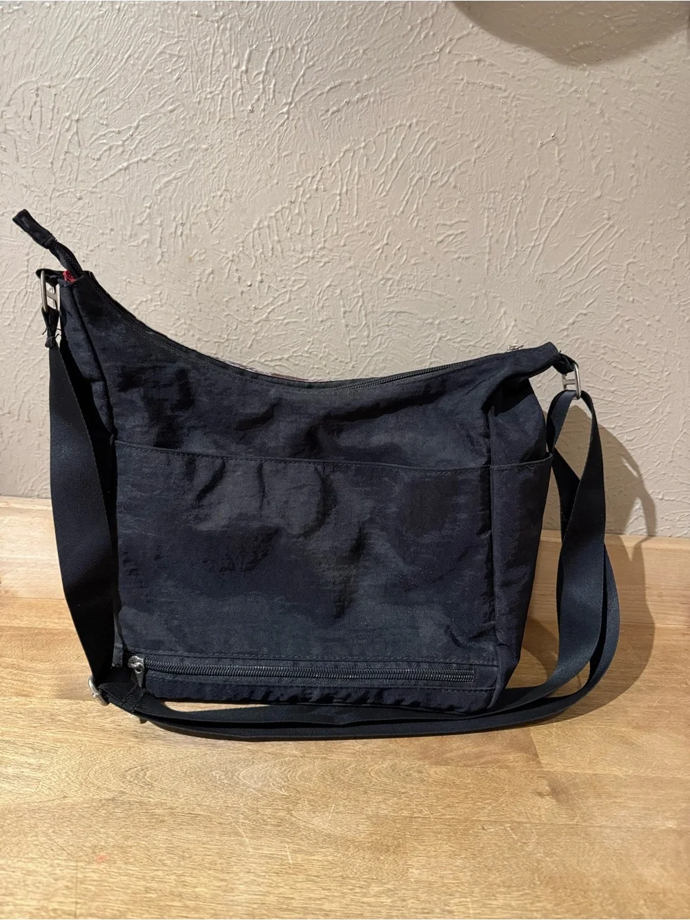 Satchelli Black Crossbody Bag with Floral Accent and Red Lining